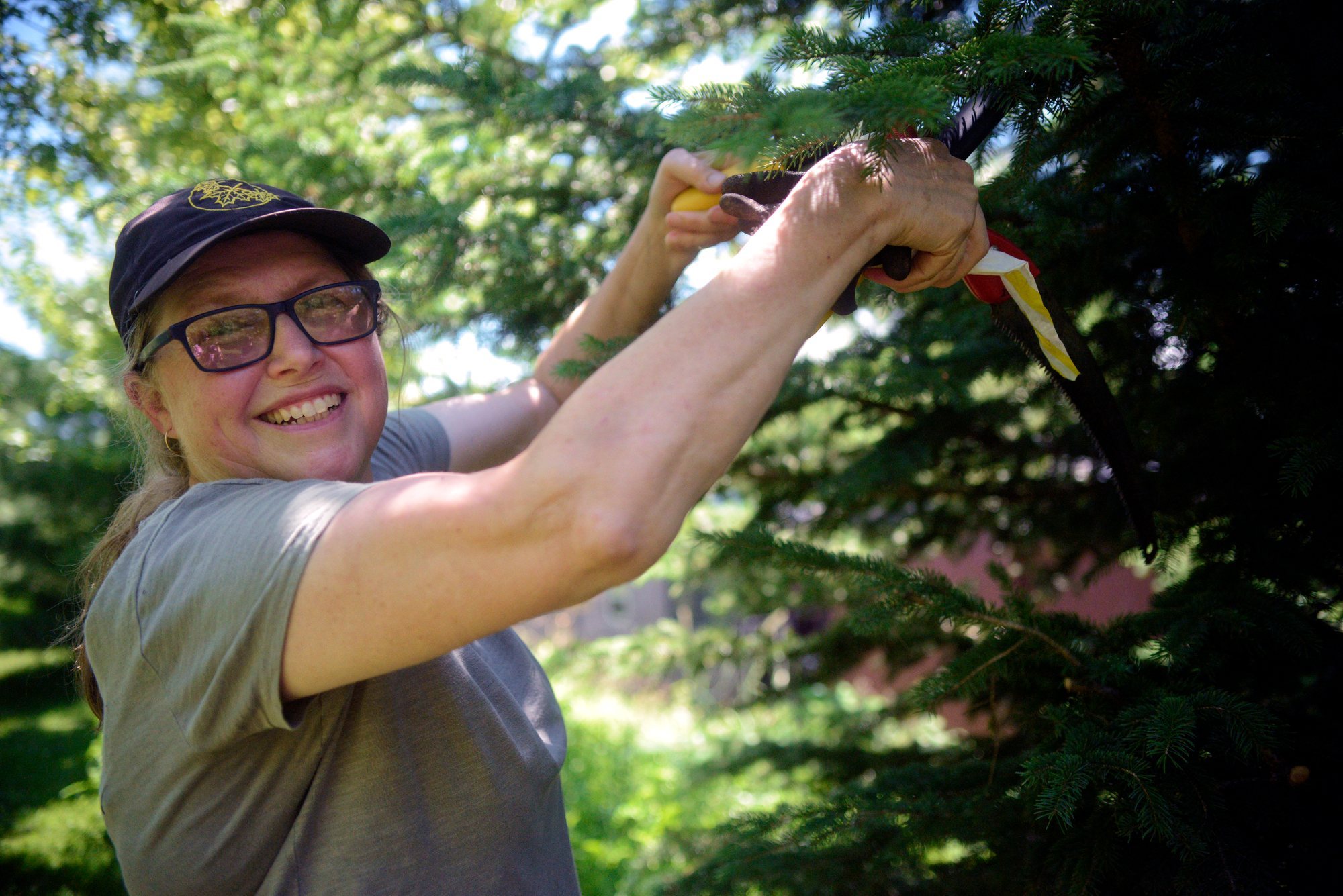 Janet volunteering outdoors while working with a tree